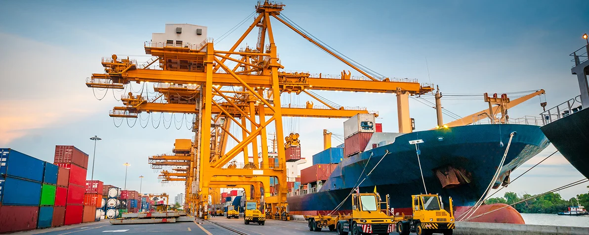 Aerial view of a busy port with cranes and vessel berths